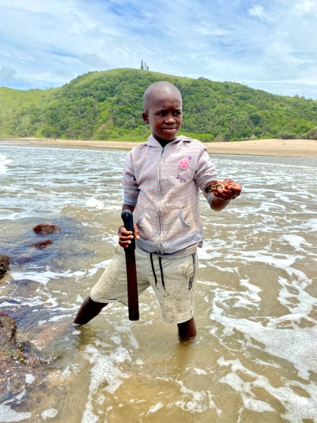 SA. Wild Coast. Boy catching oysters